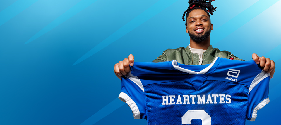 Damar Hamlin holding up a jersey representing the Abbott HeartMates program.